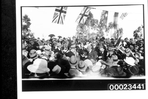 Crowd of people gathered underneath a row of flags