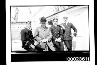 Ships and steamer crews, three men sitting and one standing on deck