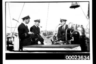 Ships and steamer crews, three men in uniform at ship's wheel