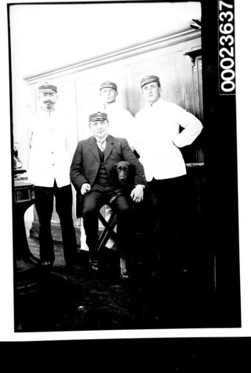 Four  ship's officers with a dog