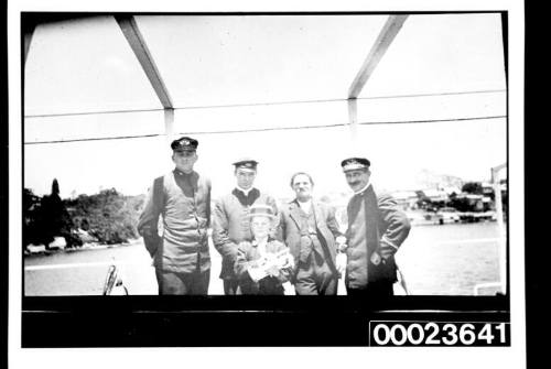 Ships and steamer crews, four men and a boy holding a trumpet on deck