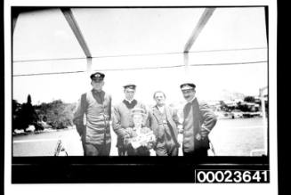 Ships and steamer crews, four men and a boy holding a trumpet on deck