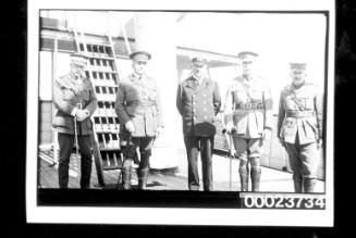 Five men in uniform on deck of a ship