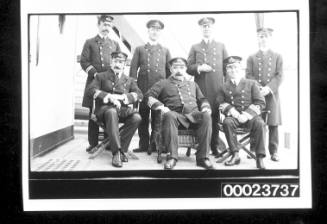 Seven men in naval uniform