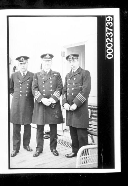 Three men in naval uniforms