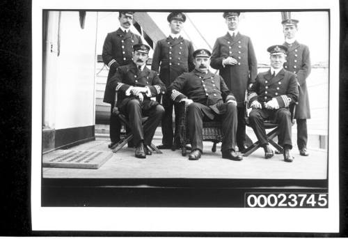 Seven men in naval uniform