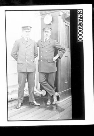 Two men standing on deck, both wearing uniforms