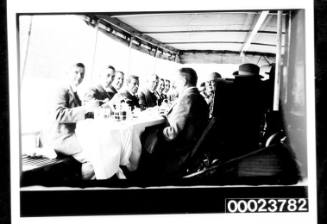 Men seated at dining table on ships deck