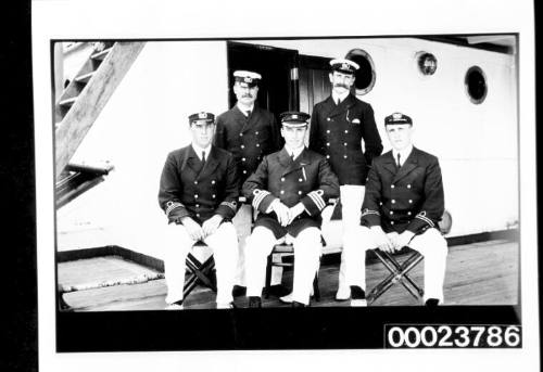 Three ship's officers seated on chairs