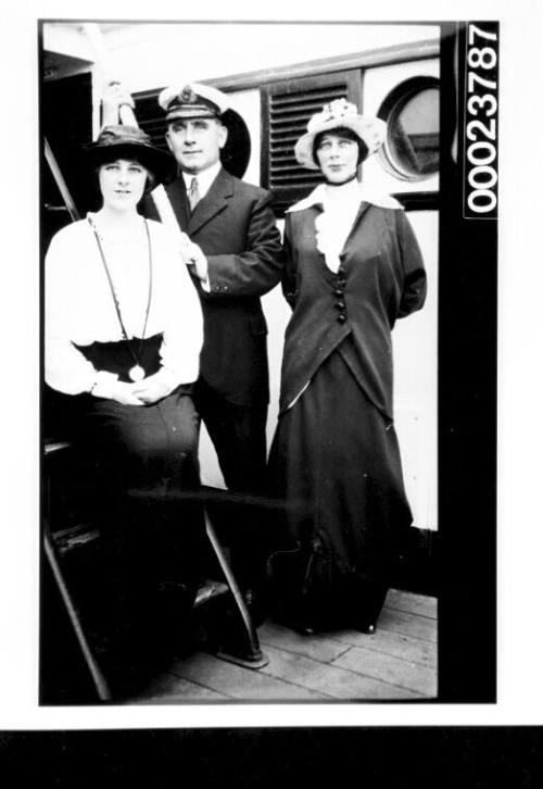 Uniformed officers and two women on deck