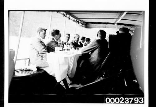 Men seated at table on covered deck