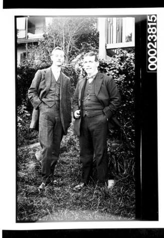 Two men standing in garden setting