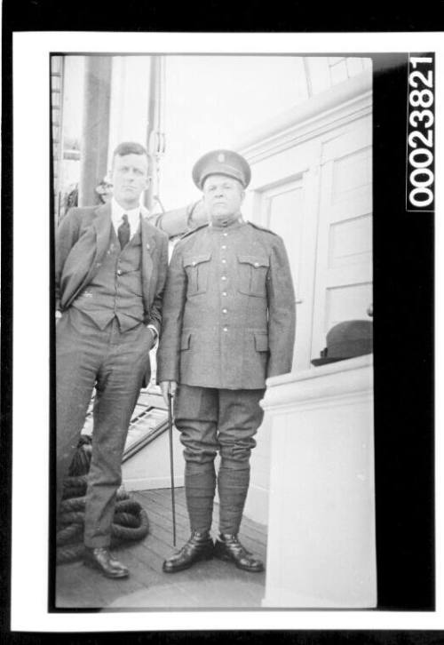 Two men on deck, one in uniform and one in civilian clothing