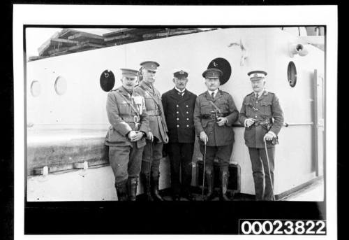 Five men in uniform on deck of a ship