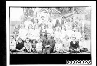 Group of boys and girls with adults standing behind them