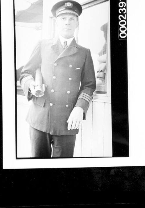 Officer on deck of ship holding telescope