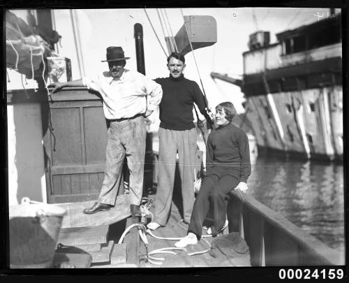 Three people gathered on a ship's deck