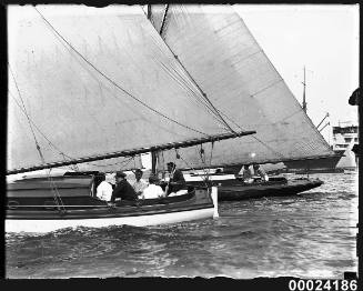 Portside view of five men seated on a cabin sailboat