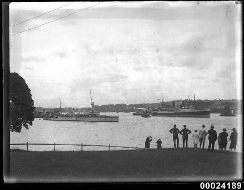 Warship and two-funnelled passenger steamer in harbour