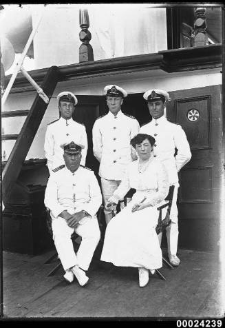 Group portrait of naval officers and a woman wearing a white dress