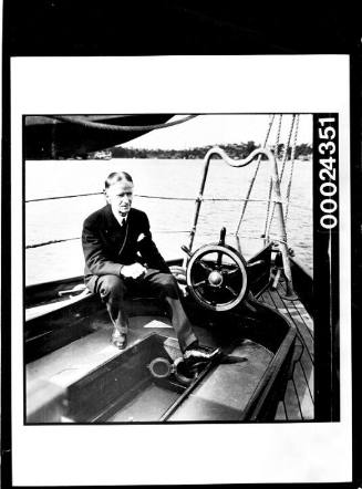 Harold Nossiter Snr in a suit at the cockpit of yacht SIRIUS
