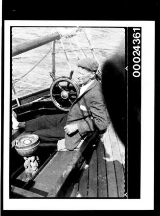 Harold Nossiter Snr at the cockpit of yacht SIRIUS
