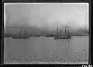 Three-masted barque and five-masted barquentine anchored in a harbour