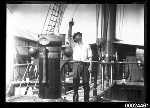 Man in civilian clothes standing on the deck of a ship