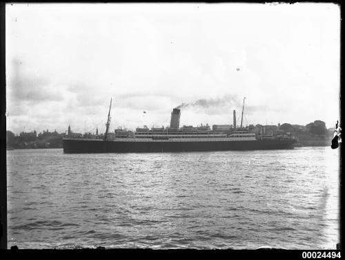 Portside view of a two-masted, single funnel passenger ship in a harbour