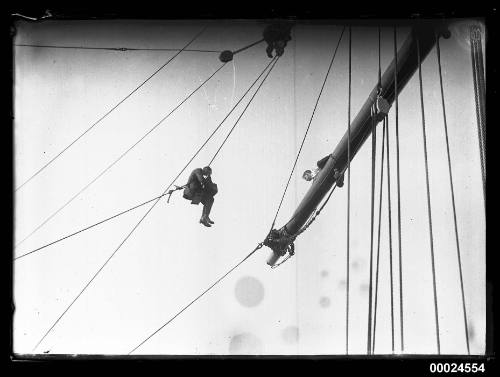 Photographer suspended from ship's rigging on ELGINSHIRE