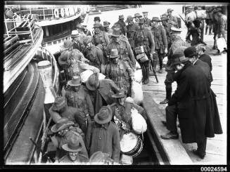 Australian Army soldiers boarding a ferry at a wharf in Sydney