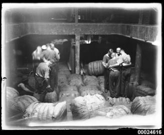 Two groups of four men standing on wool bales on board MAGDALENE VINNEN