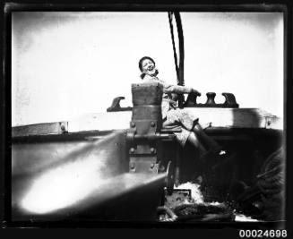 Woman seated on ship machinery, possibly on board MAGDALENE VINNEN