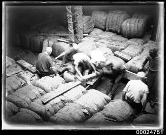 Men packing wool bales in the hold of MAGDALENE VINNEN