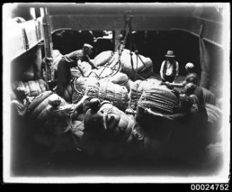 Men packing wool bales in the hold of MAGDALENE VINNEN