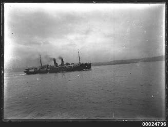 Unidentified passenger ship with twin funnels underway in harbour.