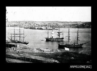 Unidentified harbour with three sails ships at anchor