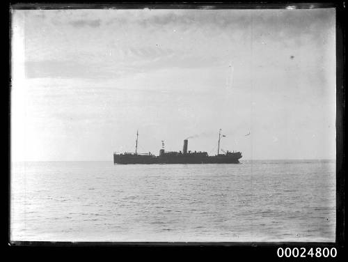 Unidentified single funnel two mast cargo ship under steam.