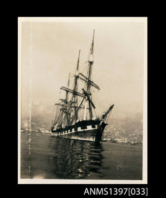 Photograph depicting a three masted vessel at sea