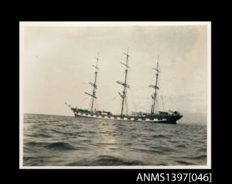 Photograph depicting a three masted vessel at sea