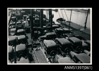 Photograph depicting a group of cars on a ship's deck