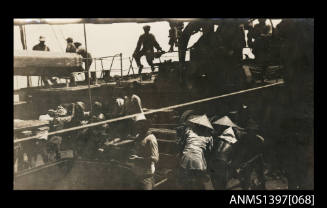 Photograph depicting a group of people working at a port