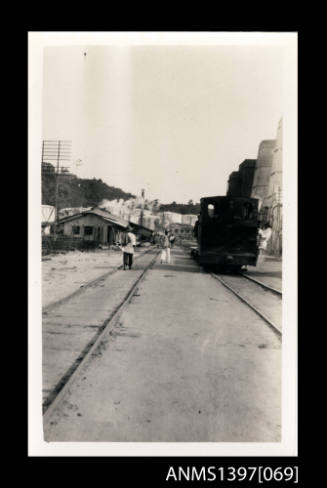 Photograph depicting a landscape with a railway and a tank engine