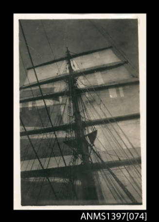 Photograph depicting the main mast of a ship in full sail