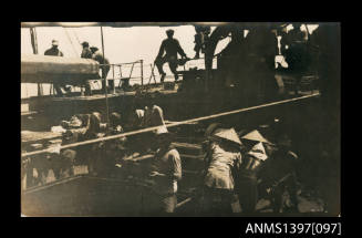 Photograph depicting a group of men working at a port
