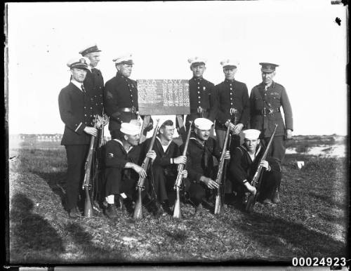 United States and Australian officers and sailors around a tally board