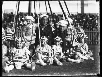 Two United States sailors with children around a maypole possibly at the Vice-Regal Garden Party