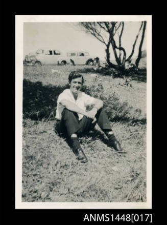Man seated on a grassy hill
