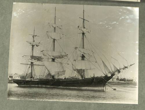 Full-rigged ship moored to a buoy very close to shore