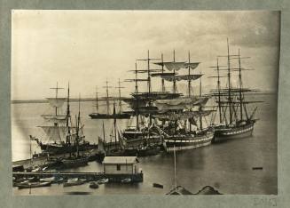 Full-rigged ships and other boats docked at a jetty